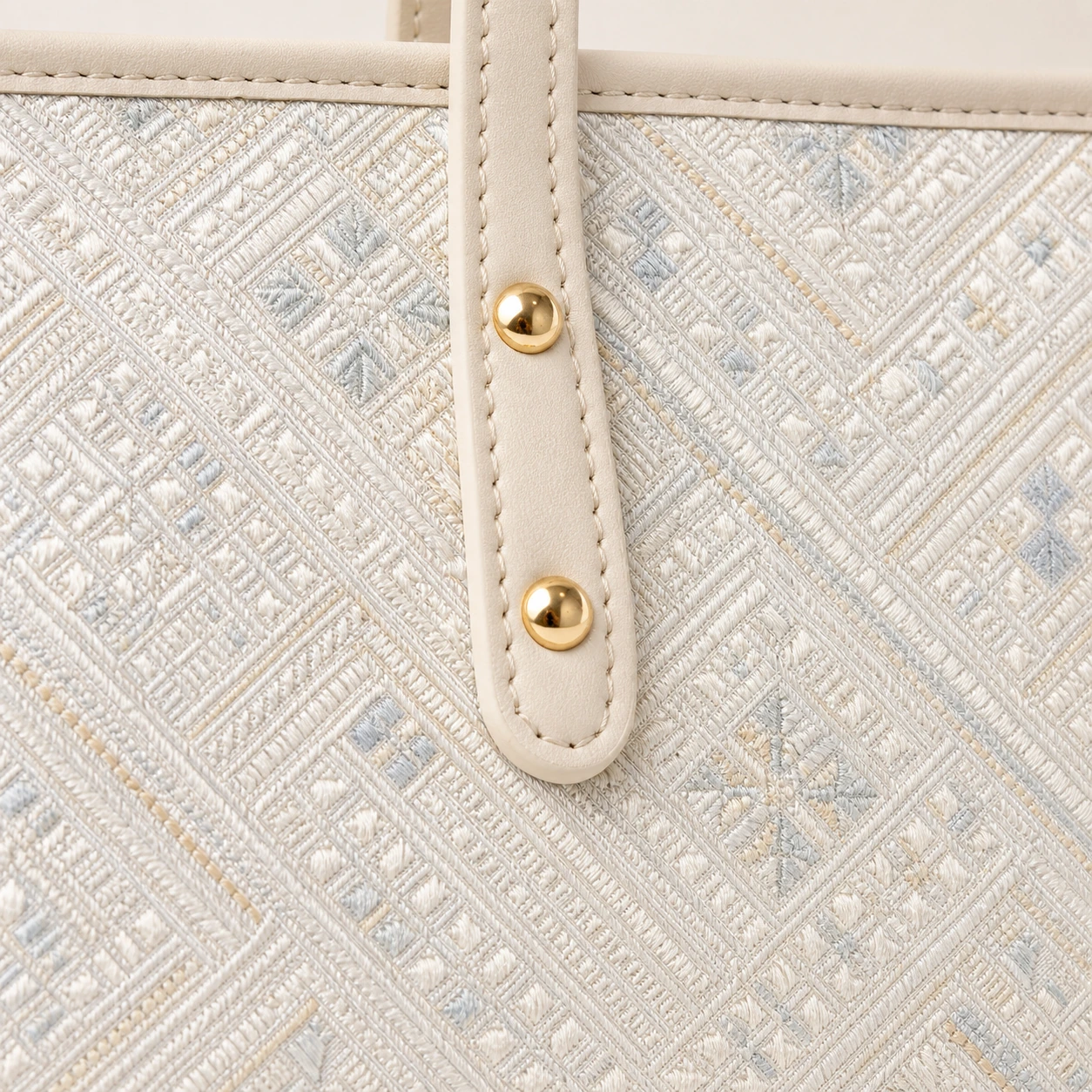 Close-up of Pearl River Tote brocade weave and leather stitching